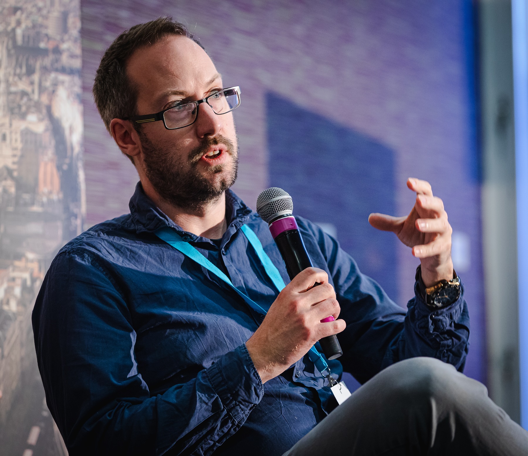 Ed is speaking into a microphone, using his hand to emphasise whatever he was saying