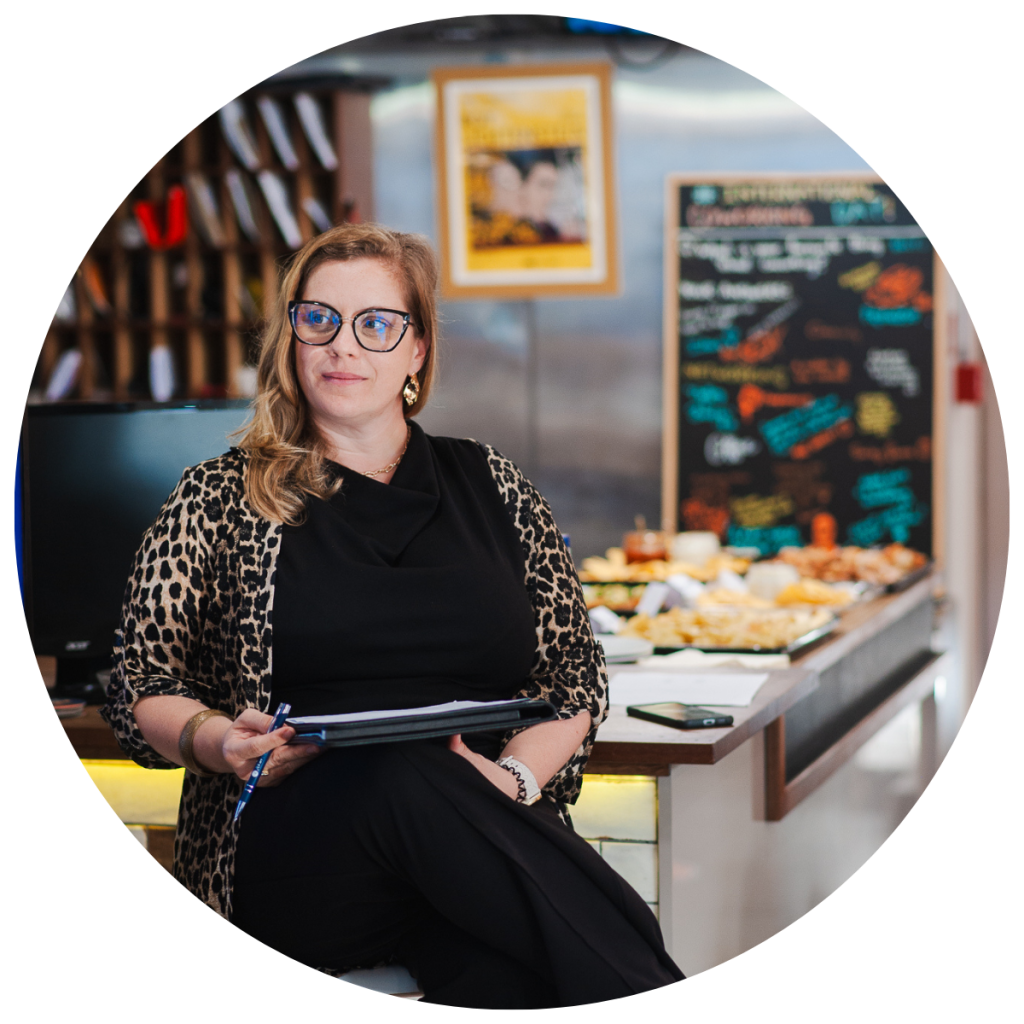 Shirah Bamber is sitting on a stool where she is hosting an event.